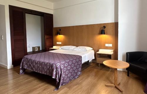 a hotel room with a bed and a table at Hotel Brasa in Elvas