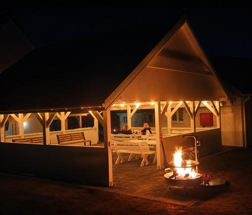 a tent with a table with a fire in it at night at Osada Pana Kraba in Jarosławiec