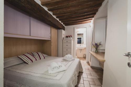 a bedroom with a bed with towels on it at Bargello House by FrancigenaApartments in Siena
