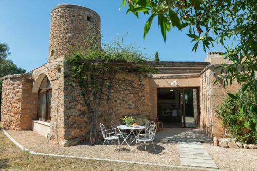 a patio with a table and chairs in front of a brick building at Finca Son Vidal in Llucmajor