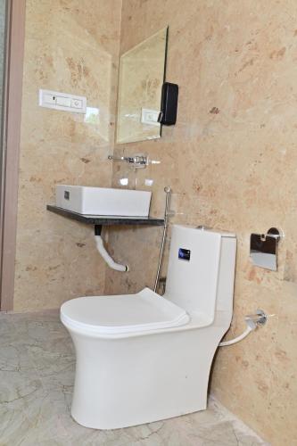 a bathroom with a white toilet and a sink at Hotel B R Residency in Bikaner