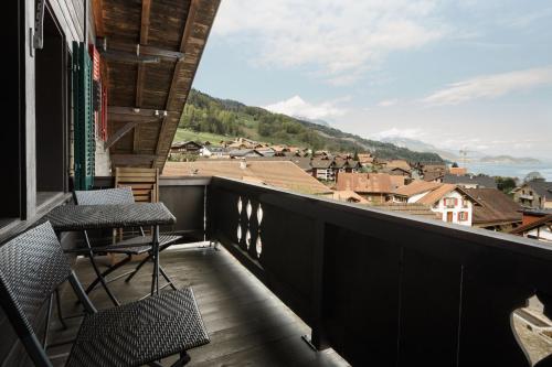 a balcony with chairs and a view of a town at Thimo's Lakeview - Sunset near Interlaken in Leissigen