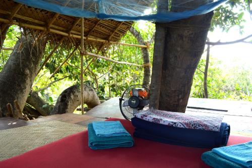 a tent with two towels and a camera on a table at Namaste Yoga Farm in Gokarna