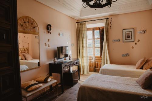 a bedroom with two beds and a mirror at Convento de Lillo in Lillo