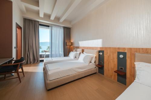 a hotel room with two beds and a desk at Chic Boutique Hotel Vlore in Vlorë