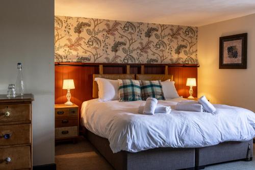 a bedroom with a large bed with two pillows at The Countryman Inn in Wool