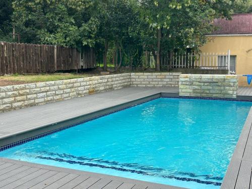 a large blue swimming pool with a wooden deck at Bella - Rosa in Ficksburg