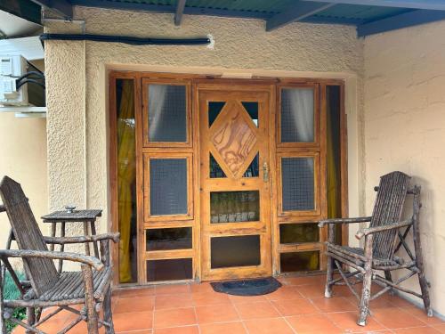 a wooden door with two chairs in front of it at Bella - Rosa in Ficksburg
