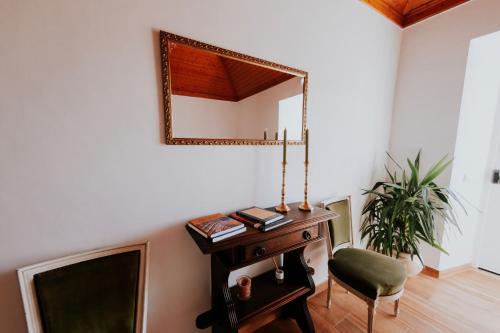 a living room with a mirror and a chair at Casa de Campo da Quinta da Pegada in Óbidos