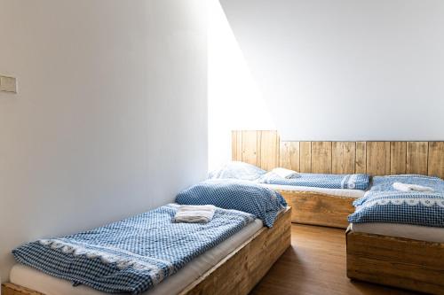 two twin beds in a room with wooden floors at Apartmán Marie in Mutěnice