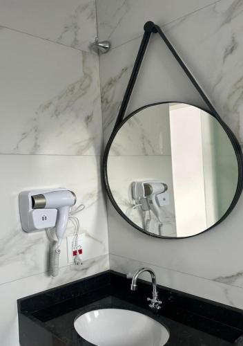 a bathroom with a mirror and a sink at Hotel Rota Dos Tropeiros in Castro