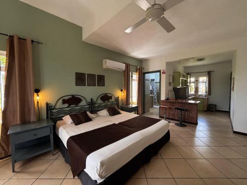 a bedroom with a large bed with a ceiling fan at Tam Studio in La Gaulette