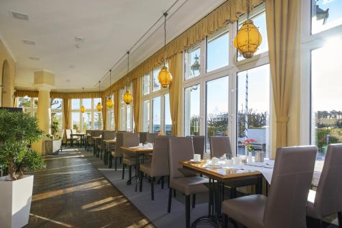 a dining room with tables and chairs and windows at Appartement 06 Strandvillen Wald & See in Zinnowitz