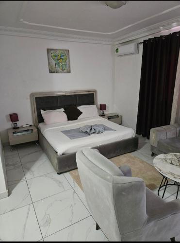 a bedroom with a bed and a couch and a chair at Hotel liberté 6 in Dakar