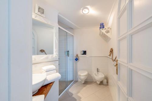 a white bathroom with a toilet and a sink at Residence Le Terrazze in Sorrento