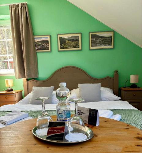 a table with a bottle of water and two beds at Grand Apartments Špindlerův Mlýn in Špindlerův Mlýn