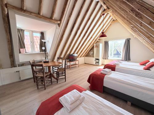 a attic bedroom with two beds and a table at Hotel - Cafe De Harmonie in Edam