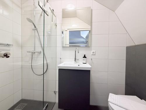 a white bathroom with a sink and a shower at Hotel - Cafe De Harmonie in Edam