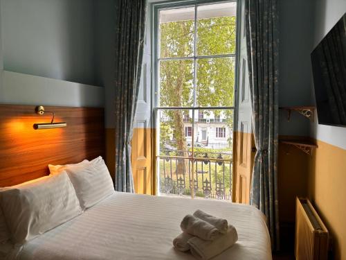 a bedroom with a bed and a large window at The Norfolk, Paddington in London