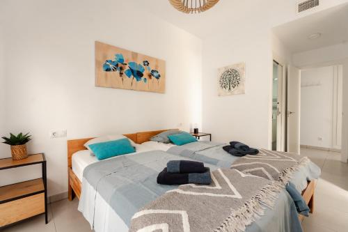 a bedroom with a large bed with blue pillows at Superior Calpe Pearl Beach in Calpe