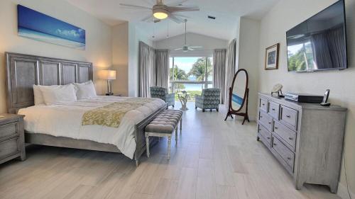 a bedroom with a bed and a dresser and a television at 406 Mariners Club in Key Largo