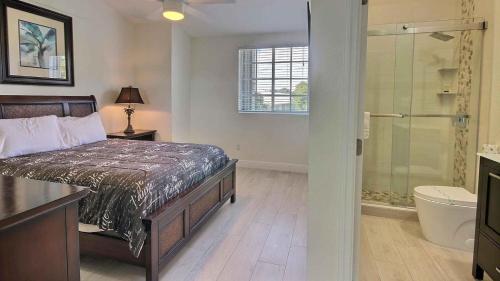 a bedroom with a bed and a glass shower at 406 Mariners Club in Key Largo