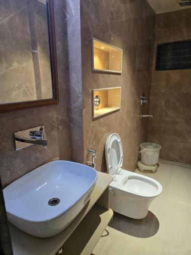 a bathroom with a white sink and a toilet at Hotel Santoor - Geeta Bhawan Square in Indore