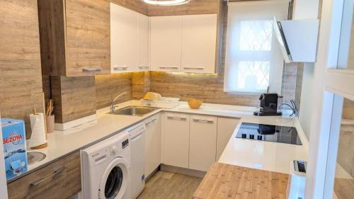 a kitchen with white cabinets and a washer and dryer at Apartamento Mar y Encanto in Miami Platja