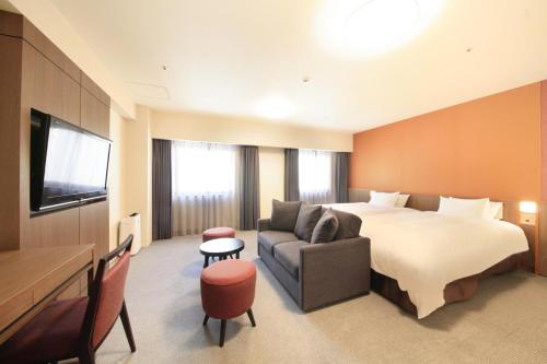 a hotel room with a bed and a couch at Richmond Hotel Kagoshima Kinseicho in Kagoshima
