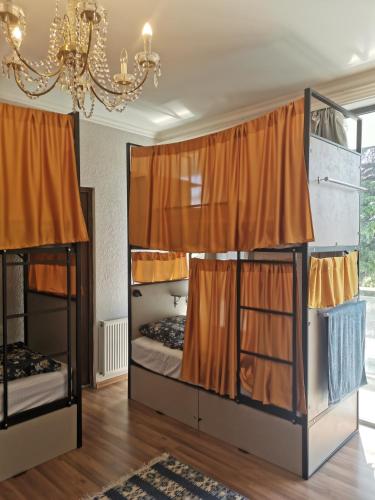 two bunk beds in a room with orange curtains at Hostel Rioni in Kutaisi