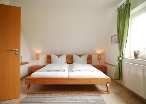 a bedroom with a bed with white sheets and a window at Villa Pepita in Kaltenhof