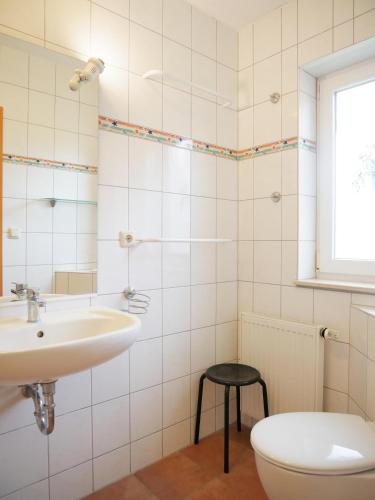 a bathroom with a sink and a toilet and a window at Villa Pepita in Kaltenhof