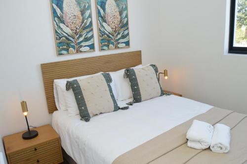 a bedroom with a bed with white sheets and pillows at Luxury Apartment Unit 101 in George