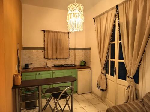 a kitchen with green cabinets and a table and a window at Sunshine in Maltezana