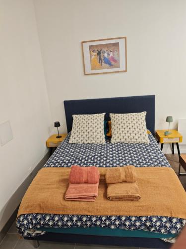 a bedroom with a bed with two towels on it at La Maison de violette meublé classé 3 étoiles in Montdidier