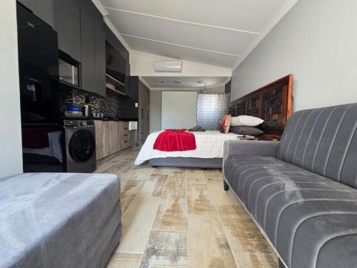 a bedroom with a bed and a couch at De Oude Sleeper Inn 2 Apartment in Kimberley