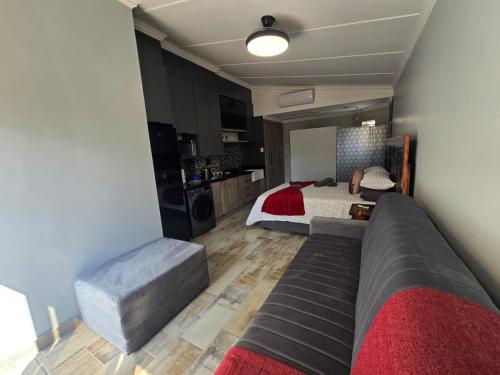 a living room with a couch and a bed at De Oude Sleeper Inn 2 Apartment in Kimberley