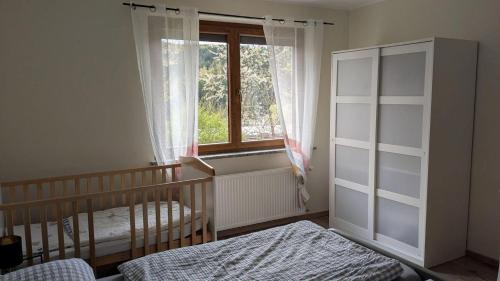 a bedroom with a crib and a window at Ferienhaus Hilde in Steinwiesen