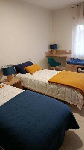 a room with two beds and a table and chairs at La PETITE MAISON in Gourdan-Polignan
