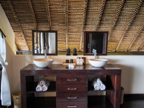 a bathroom with two sinks and two mirrors at Villa Bossi Bali at Tanguwesia in Bubunan