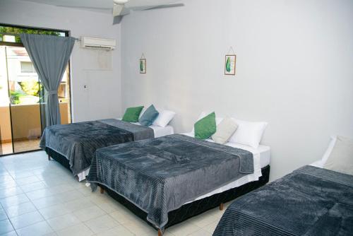 a room with two beds and a window at GuestHouse Encanto del Centro in Encarnación