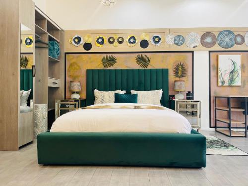a bedroom with a large bed with a green headboard at 24 On Basil Boutique Luxury hotel in Johannesburg