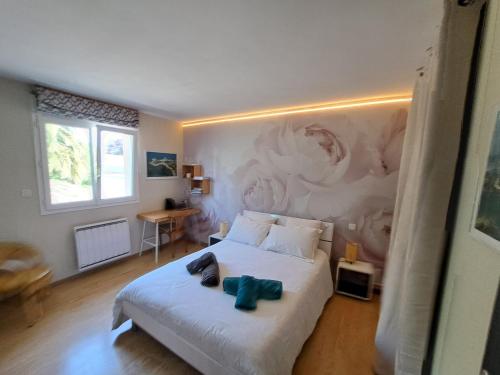 a bedroom with a bed with a painting on the wall at Chambre d'Hôtes Valérie in Penvénan