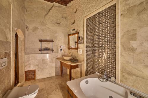 a bathroom with a tub and a toilet and a sink at Mithra Cave Cappadocia in Göreme