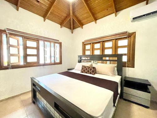 a bedroom with a large bed in a room with windows at villa regazo de paz in Concepción de La Vega