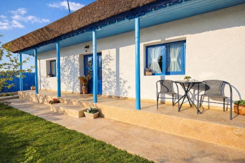 a patio with a table and chairs next to a house at Casa lui Matei Murighiol#2 in Murighiol
