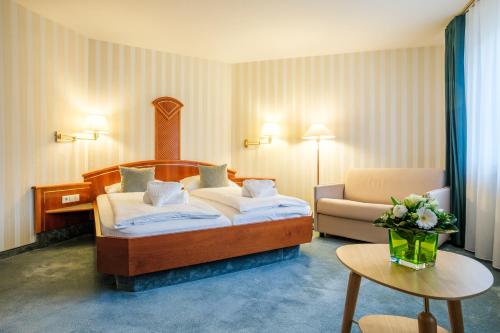 a bedroom with a bed and a couch and a table at Hotel Wartburg in Stuttgart