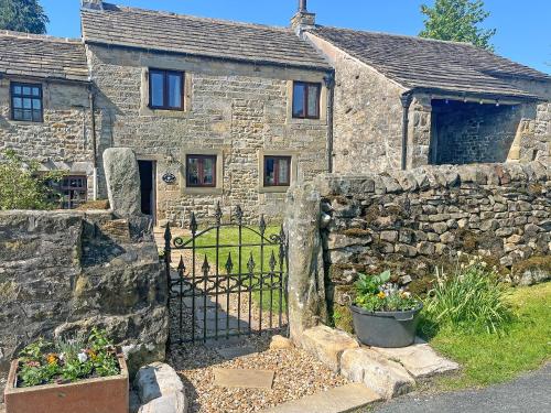 an old stone house with a gate and a stone wall at Bradley House in Harrop Fold
