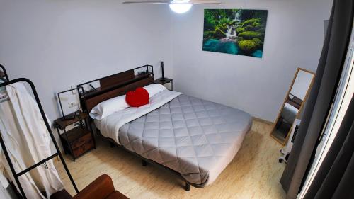 a bedroom with a bed with a red pillow on it at Ruralux Sierra Quesada in Quesada