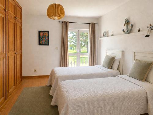 a bedroom with two beds and a window at Troia Apartments in Troia